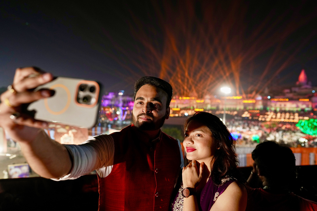 A couple takes a selfie along the Saryu river during Deepotsav celebrations on the eve of Diwali in Ayodhya, India, Sunday, Oct. 19, 2025. (AP Photo/Rajesh Kumar Singh)