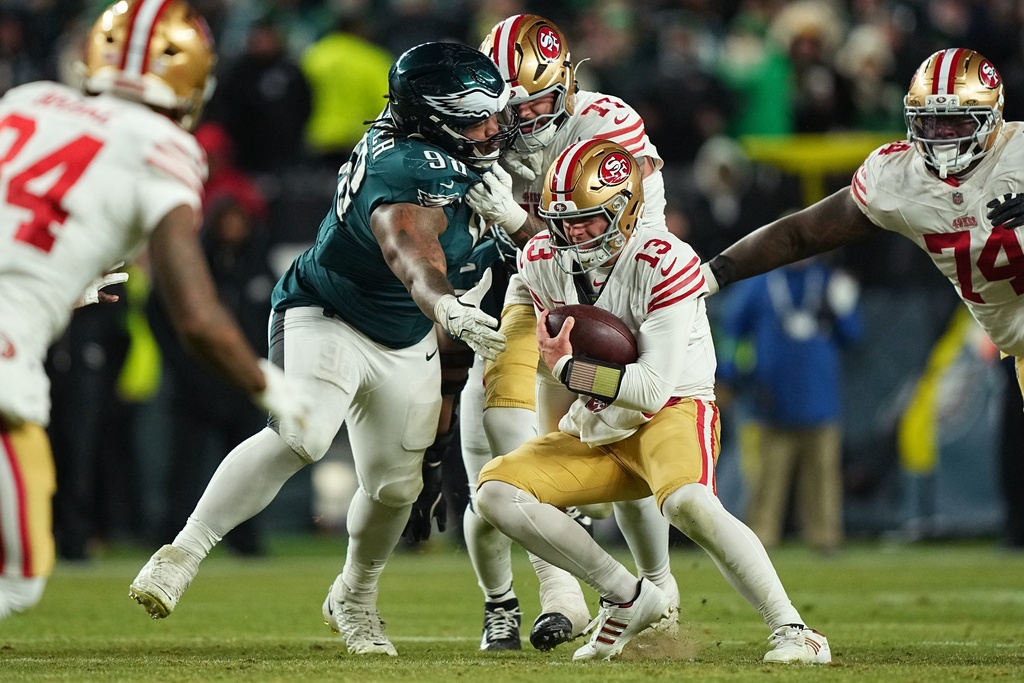 Philadelphia Eagles defensive tackle Jalen Carter (98) tries to stop San Francisco 49ers quarterback Brock Purdy (13) during the second half of an NFL wild-card playoff football game Sunday, Jan. 11, 2026, in Philadelphia. (AP Photo/Matt Rourke)