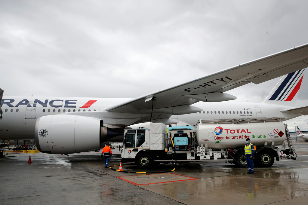 FILE - Workers refuel an Airbus A350 with sustainable aviation fuel at Roissy airport, north of Paris, Tuesday, May 18, 2021. (AP Photo/Christophe Ena, File)