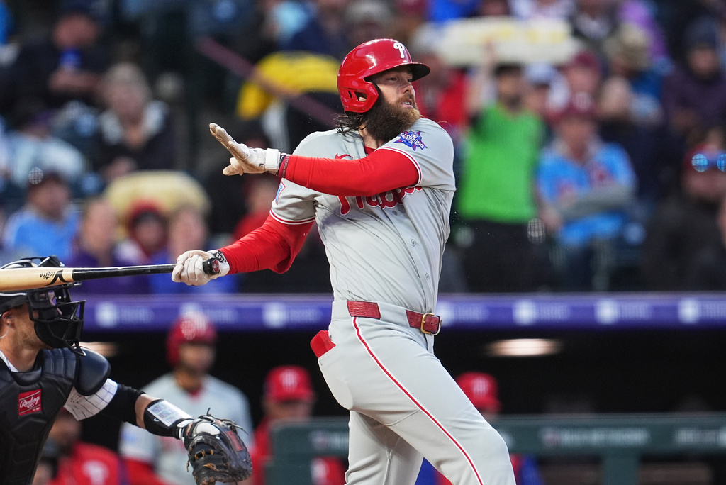 Philadelphia Phillies' Brandon Marsh singles off Colorado Rockies relief pitcher Chase Dollander in the fifth inning of a baseball game Saturday, April 4, 2026, in Denver. (AP Photo/David Zalubowski)