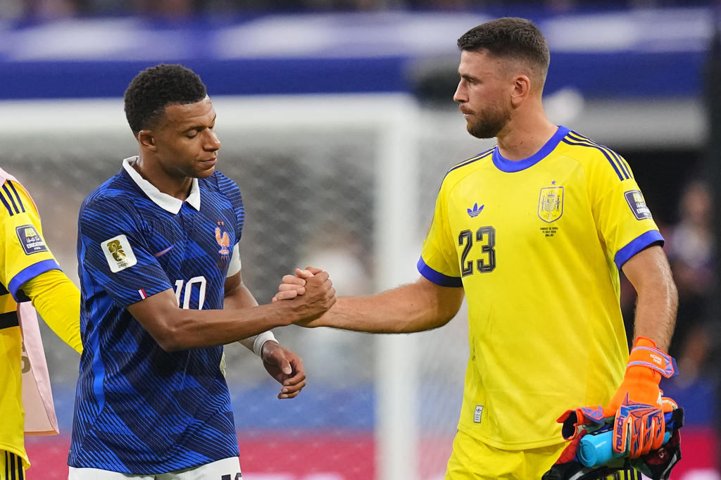 France's Kylian Mbappe (10) and Spain goalkeeper Unai Simon (23) shake hands after the World Cup semifinal soccer match between France and Spain in Arlington, Texas, near Dallas, Tuesday, July 14, 2026. (AP Photo/Julio Cortez)