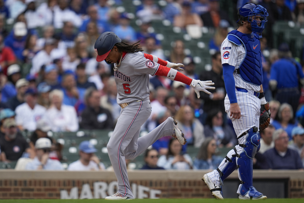 Washington Nationals' CJ Abrams (5) runs by Chicago Cubs catcher Carson Kelly (15) to score on a single from Washington Nationals catcher Jorge Alfaro (44) during the first inning of a baseball game Saturday, Sept. 6, 2025, in Chicago. (AP Photo/Erin Hooley)