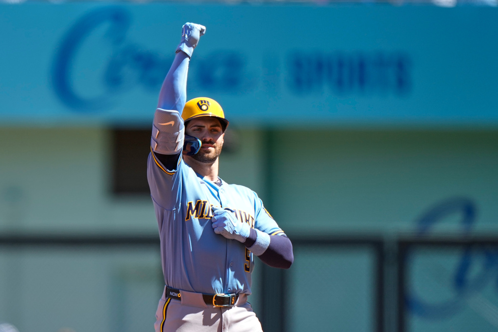 Milwaukee Brewers' Garrett Mitchell celebrates on second after hitting a two-run double during the first inning in the first baseball game of a doubleheader against the Kansas City Royals, Saturday, April 4, 2026, in Kansas City, Mo. (AP Photo/Charlie Riedel)