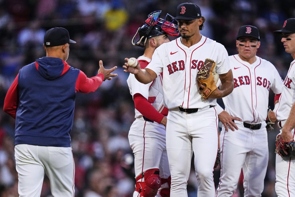 Boston Red Sox pitcher Jordan Hicks, center right, gives the ball to manager Alex Cora while getting pulled in the second inning of a baseball game against the Cleveland Guardians at Fenway Park, Wednesday, Sept. 3, 2025, in Boston. (AP Photo/Charles Krupa)