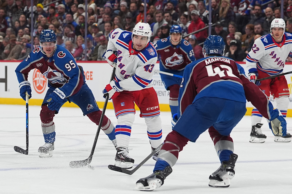 New York Rangers left wing Conor Sheary (43) drives with the puck between Colorado Avalanche left wing Victor Olofsson, left, and defenseman Josh Manson, front right, in the second period of an NHL hockey game Thursday, Nov. 20, 2025, in Denver. (AP Photo/David Zalubowski)