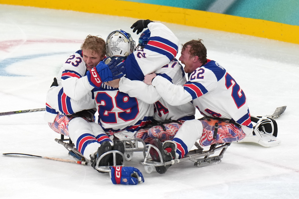 United States' players celebrates after winning the ice hockey gold medal match between United States and Canada at the 2026 Winter Paralympics, in Milan, Italy, Sunday, March 15, 2026. (AP Photo/Antonio Calanni)