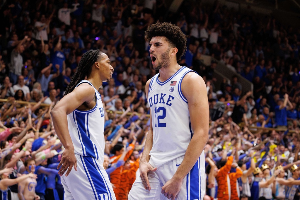 Duke's Cameron Boozer (12) and Maliq Brown, left, react after a play during the first half of an NCAA college basketball game against North Carolina in Durham, N.C., Saturday, March 7, 2026. (AP Photo/Ben McKeown)