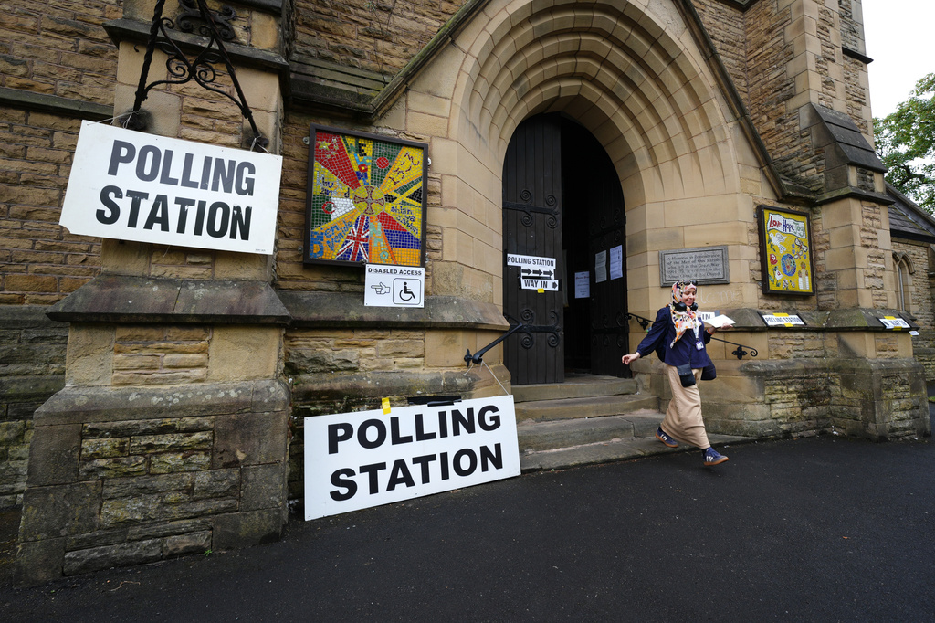 A voter leaves a polling station at St Chrysostom's Church, as voting gets underway in the Greater Manchester mayoral by-election, in Manchester, England, Thursday July 30, 2026. (Annabelle Lee-Ellis/PA via AP)