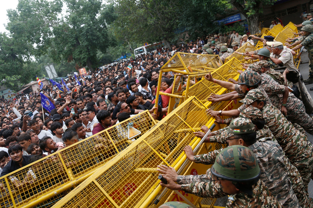 Supporters of the Cockroach Janta Party push against a barricade as they attempt to march to India's Parliament, demanding the resignation of the education minister, in New Delhi, Monday, July 20, 2026. (AP Photo/Shekhar Yadav)