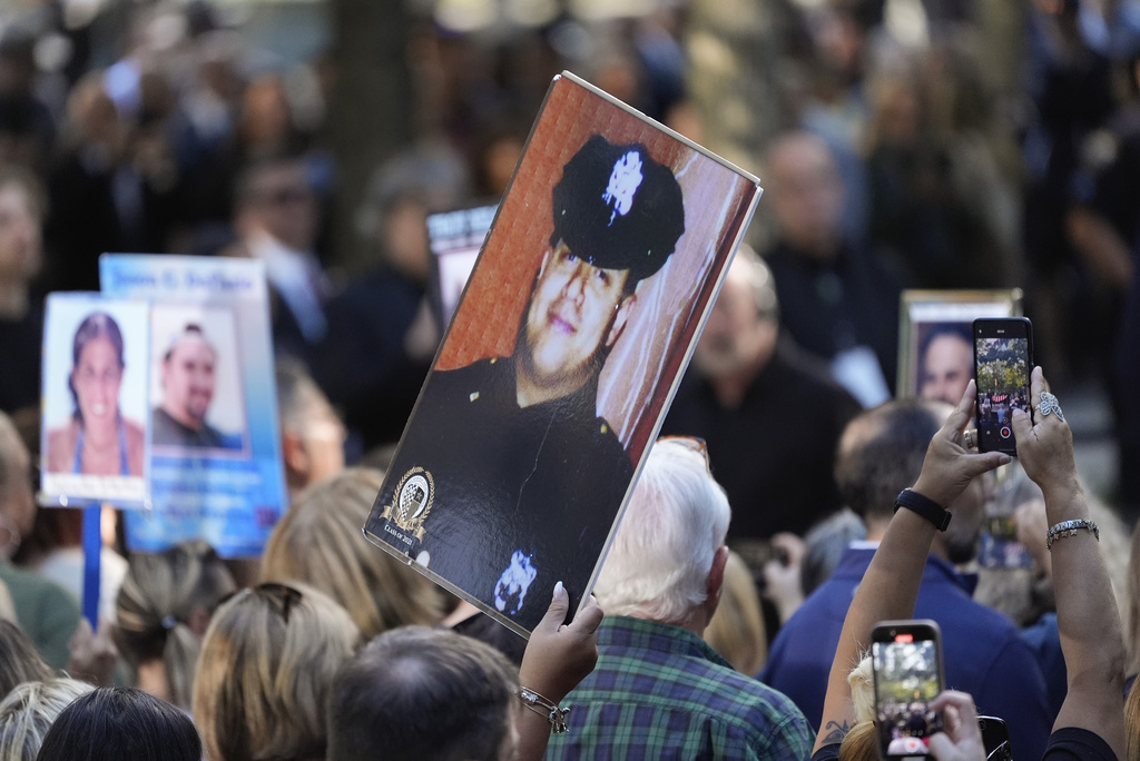 FILE - A woman holds up a photo of a New York City Police officer during the 9/11 Memorial ceremony on the 23rd anniversary of the Sept. 11, 2001 attacks, Sept. 11, 2024, in New York. (AP Photo/Pamela Smith, File)