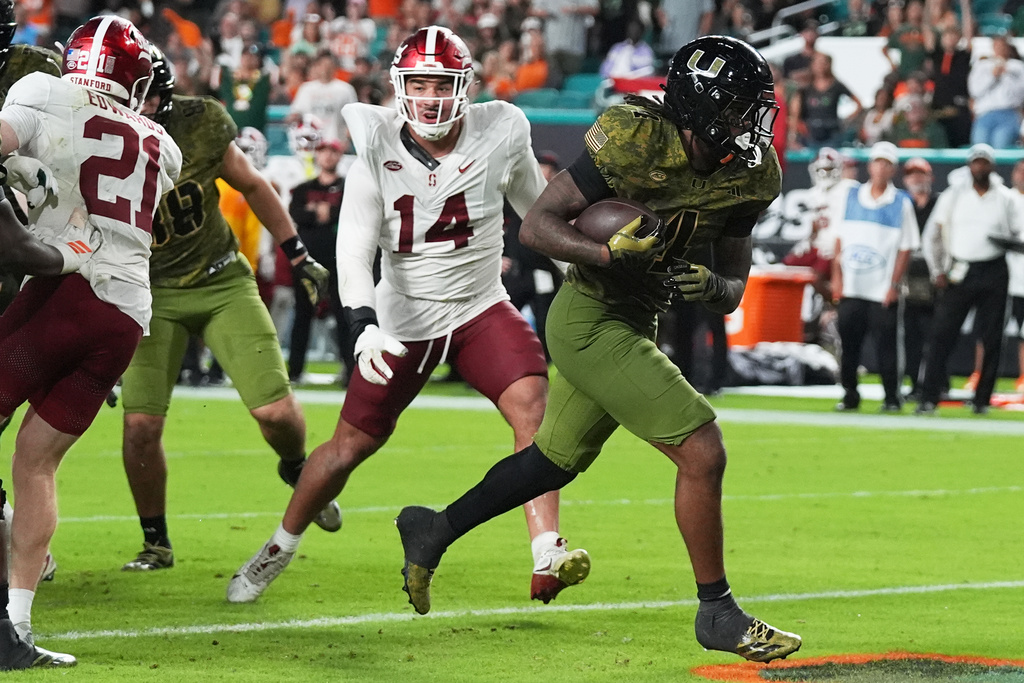 Miami running back Mark Fletcher Jr. (4) scores a touchdown past Stanford linebacker Wilfredo Aybar (14) during the second half of an NCAA college football game, Saturday, Oct. 25, 2025, in Miami Gardens, Fla. (AP Photo/Lynne Sladky)