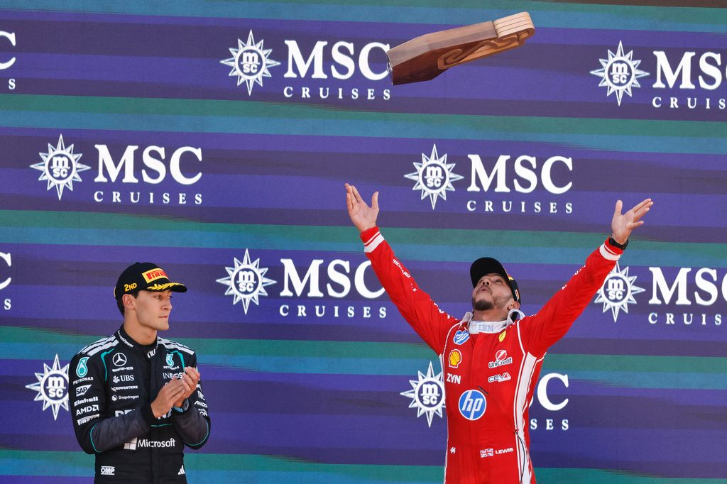 Ferrari driver Lewis Hamilton, right, of Britain celebrates on the podium next to countryman Mercedes driver George Russell, second place, after winning the Spain F1 Grand Prix race at the Barcelona Catalunya racetrack in Montmelo, near Barcelona, Spain, Sunday, June 14, 2026. (AP Photo/Joan Monfort)