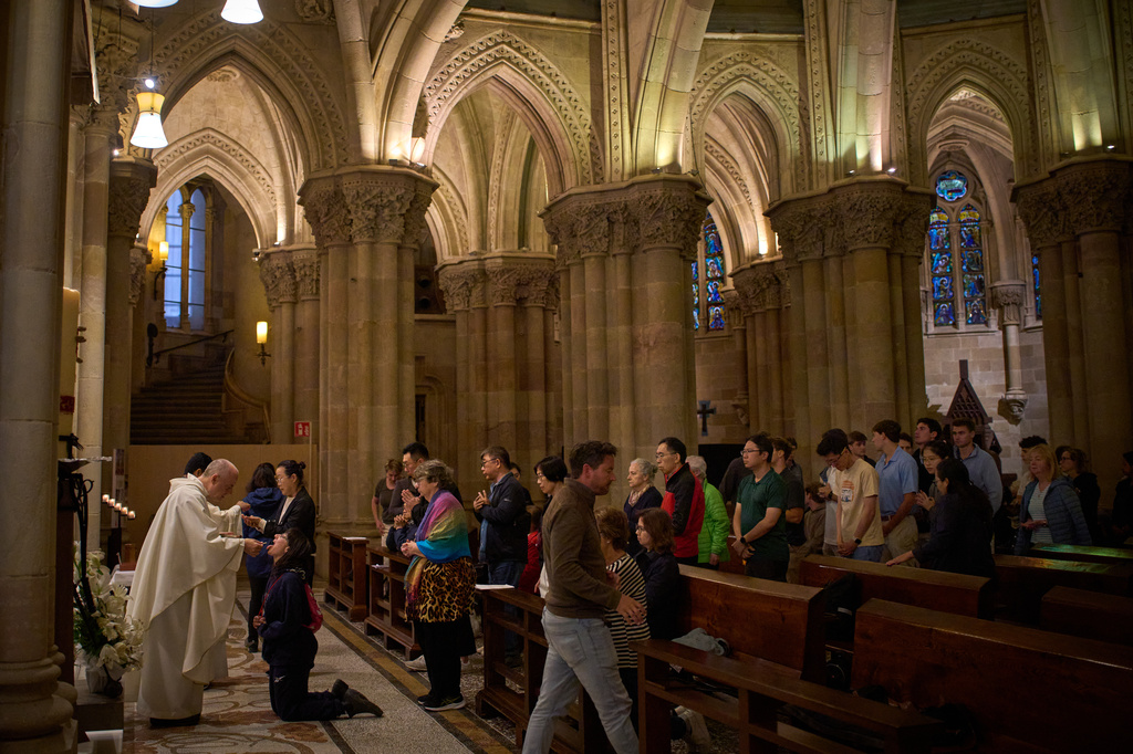 Worshippers receive communion during a Mass in the crypt of the Sagrada Familia in Barcelona, Spain, on Friday, May 15, 2026. (AP Photo/Emilio Morenatti)