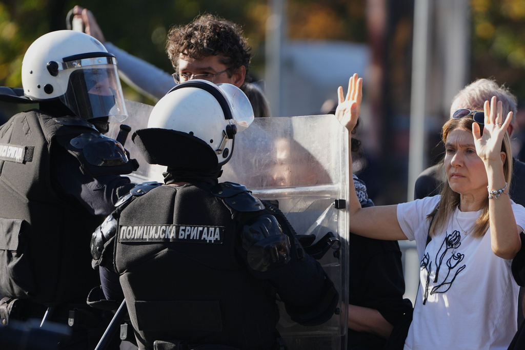 Serbian police guard a camp of President Aleksandar Vucic's loyalists as Dijana Hrka, the mother of one of 16 victims of a train station tragedy in northern Serbia a year ago, launched a hunger strike surrounded by anti-government protesters in Belgrade, Serbia, Sunday, Nov. 2, 2025. (AP Photo/Darko Vojinovic)