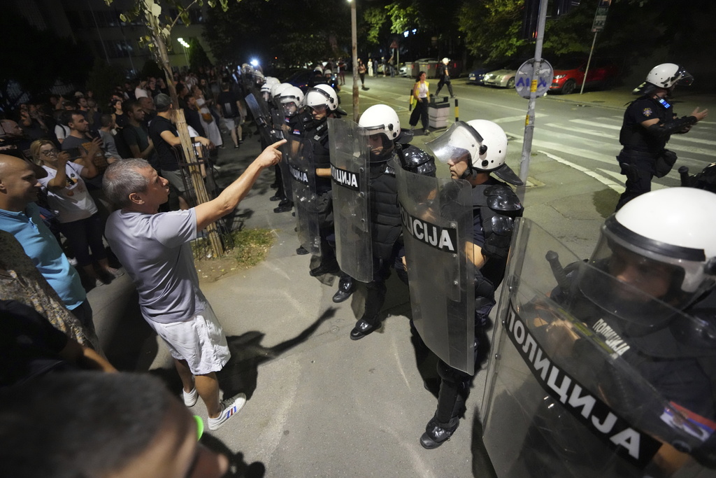 An anti-government protester talks to police officers during an anti-government protest in Belgrade, Serbia, Thursday, Aug. 14, 2025. (AP Photo/Darko Vojinovic)