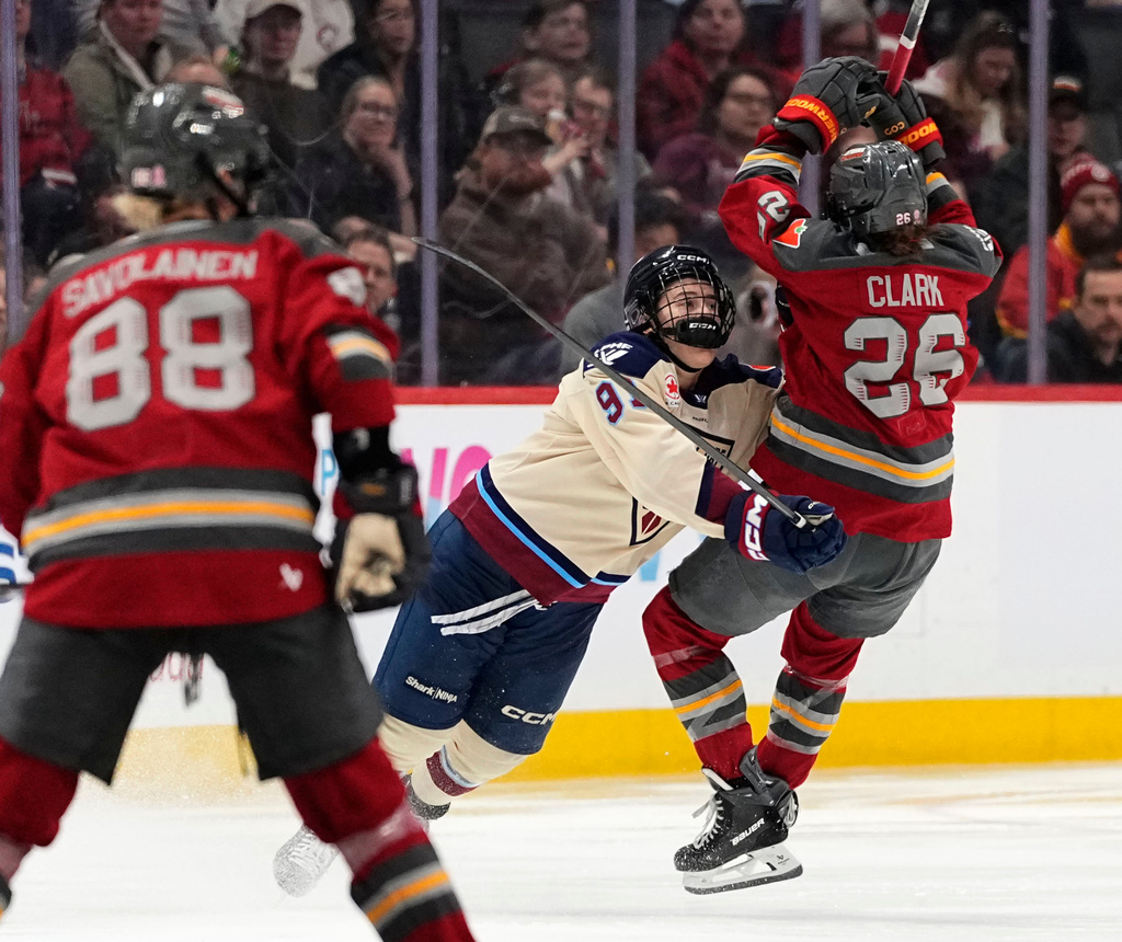 Montreal Victoire's Maggie Flaherty (91) knocks Ottawa Charge's Emily Clark (26) off her skates during second-period PWHL hockey game action in Ottawa, Ontario, Friday, April 3, 2026. (Justin Tang/The Canadian Press via AP)