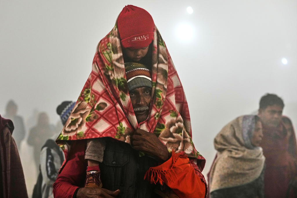 Devotees arrive for a holy dip on Mauni Amavasya, a divine occasion in Hindu religious practice followed for honoring ancestors or forefathers, at the Sangam, the confluence of the Ganges, the Yamuna and the mythical Saraswati rivers, during the annual month long Hindu religious fair "Magh Mela" in Prayagraj, India, Sunday, Jan. 18, 2026. (AP Photo/Rajesh Kumar Singh)