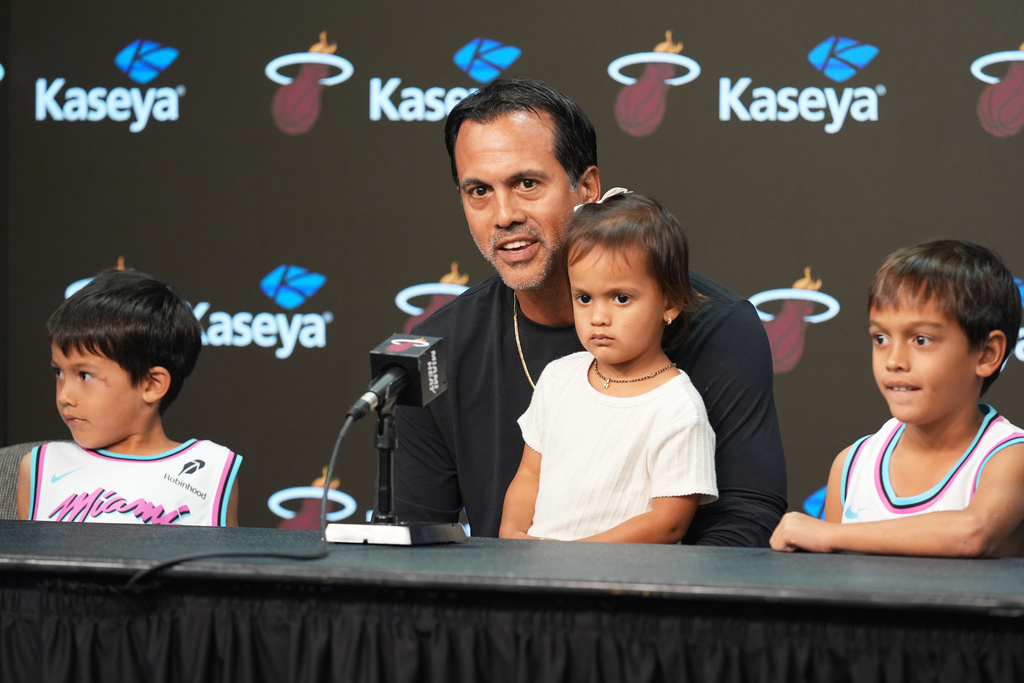 Miami Heat head coach Erik Spoelstra sits with his children as he talks about a fire that destroyed his home before an NBA Cup basketball game against the Charlotte Hornets Friday, Nov. 7, 2025, in Miami. (AP Photo/Marta Lavandier)