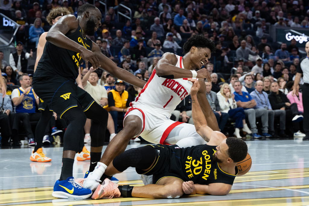 Golden State Warriors guard Stephen Curry (30) and Houston Rockets guard Amen Thompson (1) make contact during the second half of an Emirates NBA Cup basketball game Wednesday, Nov. 26, 2025, in San Francisco. (AP Photo/Benjamin Fanjoy)