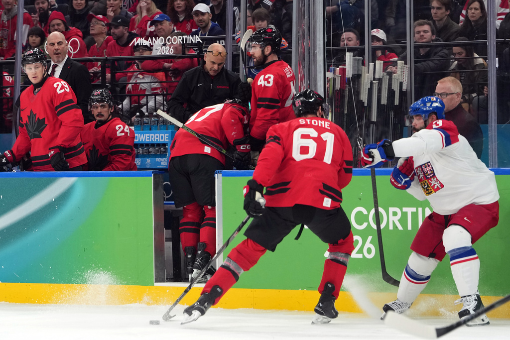 Canada's Sidney Crosby (87) is helped as he leaves the bench after being checked against the boards during the second period of a men's ice hockey quarterfinal game between Canada and Czechia at the 2026 Winter Olympics, in Milan, Italy, Wednesday, Feb. 18, 2026. (AP Photo/Carolyn Kaster)