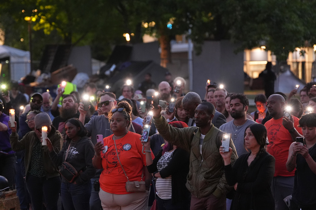 People hold smartphone with flash light during the vigil for victims the day after a shooting at Seattle Center during the Bite of Seattle food festival, Monday, July 27, 2026, in Seattle. (AP Photo/Lindsey Wasson)