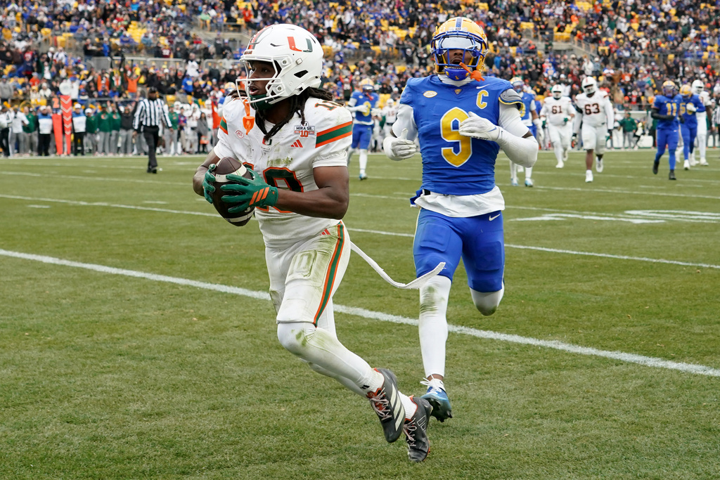 Miami wide receiver Malachi Toney (10) scores in front of Pittsburgh linebacker Kyle Louis (9) during the first half of an NCAA college football game, Saturday, Nov. 29, 2025, in Pittsburgh. (AP Photo/Matt Freed)