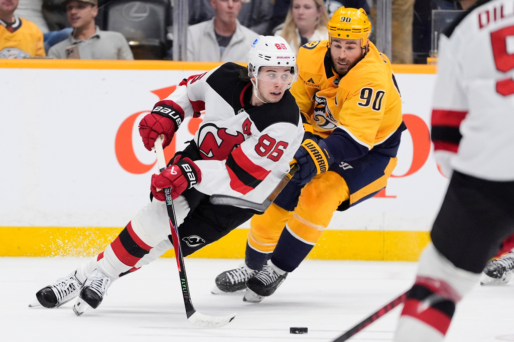 New Jersey Devils center Jack Hughes (86) skates the puck past Nashville Predators center Ryan O'Reilly (90) during the second period of an NHL hockey game Thursday, March 26, 2026, in Nashville, Tenn. (AP Photo/George Walker IV)