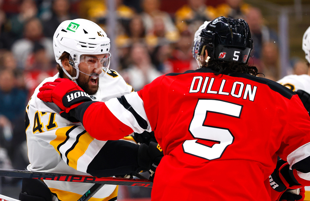 Boston Bruins' Mark Cotter (47) and New Jersey Devils' Brenden Dillon (5) fight during the first period of an NHL hockey game, Monday, March 16, 2026, in Newark, N.J. (AP Photo/Noah K. Murray)