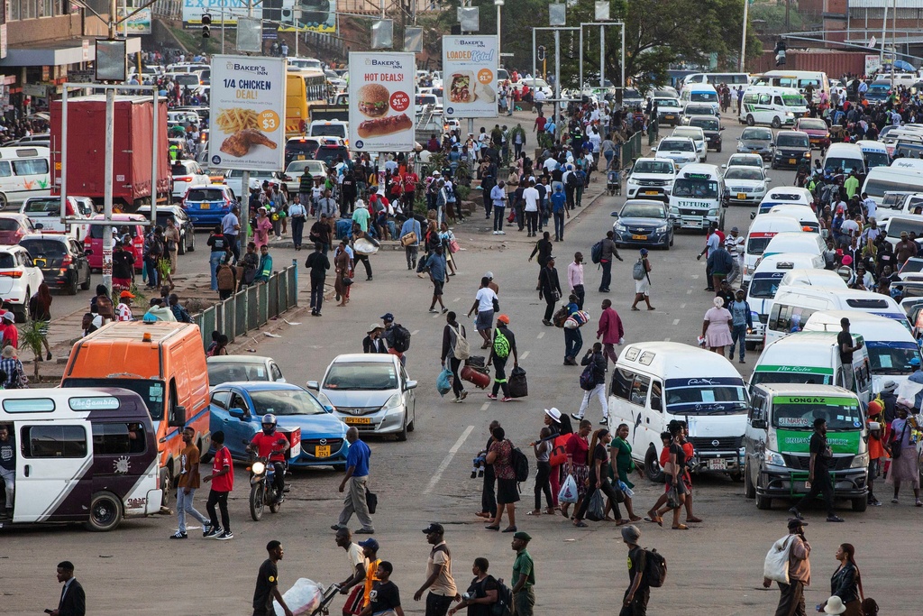 An overview of commuters at a minibus taxi area during rush hour in downtown Harare, Zimbabwe, Tuesday, Dec. 16, 2025.(AP Photo/Aaron Ufumeli)