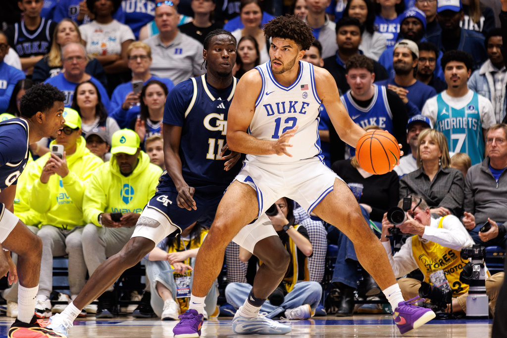 Duke's Cameron Boozer (12) handles the ball as Georgia Tech's Baye Ndongo (11) defends during the first half of an NCAA college basketball game in Durham, N.C., Wednesday, Dec. 31, 2025. (AP Photo/Ben McKeown)