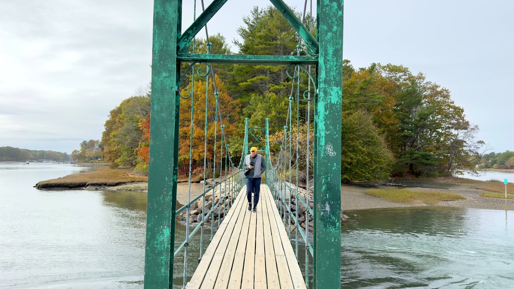 Visitors walk on Wiggly Bridge in York, Maine, on their way to view fall foliage on Tuesday, Oct. 14, 2025. (AP Photo/Rodrique Ngowi)