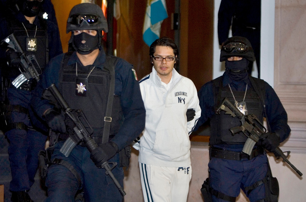 FILE - Federal police officers escort Vicente Carrillo Leyva, the alleged second-in-command of the Juarez Cartel, during his presentation to the media in Mexico City, April 2, 2009. (AP Photo/Eduardo Verdugo, File)