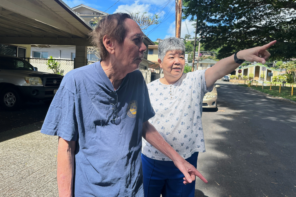 Mason Aiona, left, and Leona Aiona point out feral chickens near their home in Honolulu on Feb, 6, 2026. (AP Photo/Jennifer Sinco Kelleher)