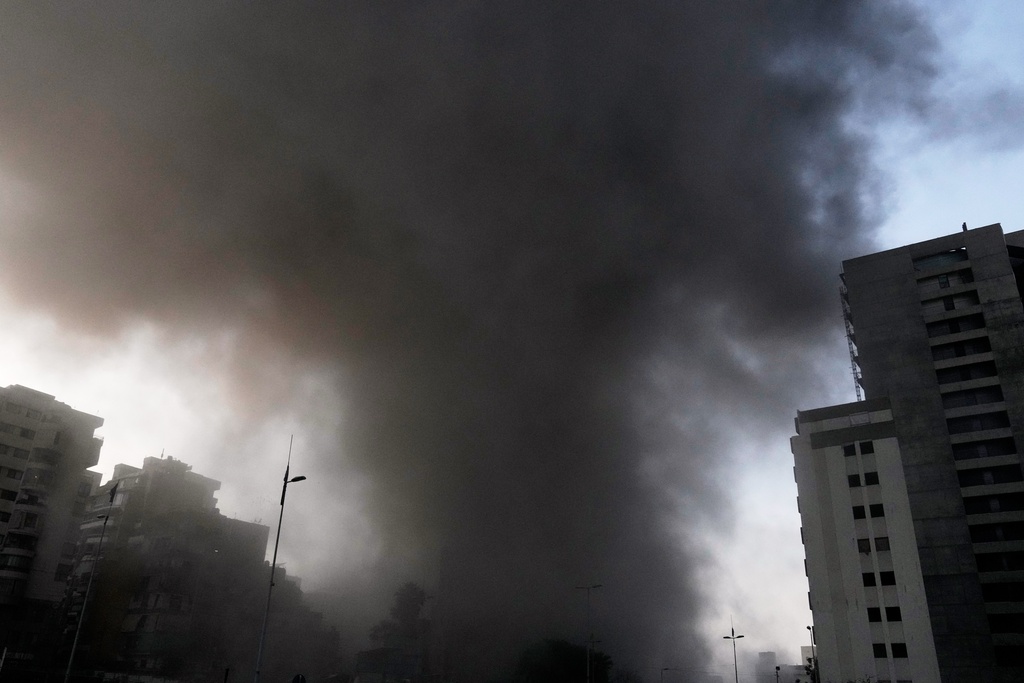 Smoke rises from a building targeted by an Israeli strike in central Beirut, Lebanon, Thursday, March 12, 2026. (AP Photo/Bilal Hussein)