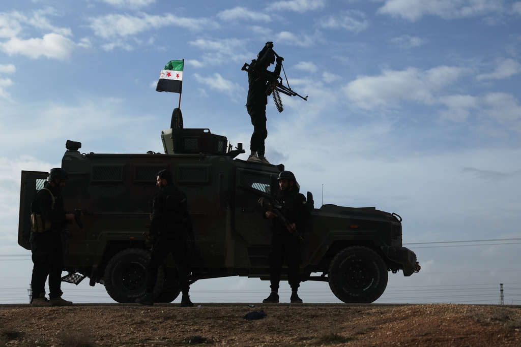 A vehicle pauses as a convoy of Syria's Interior Ministry forces passes through en route to the town of Qamishli, where the forces deploy under a ceasefire agreement with the Kurdish-led Syrian Democratic Forces (SDF), near the village of Mazraat al-Nahar, northeastern Syria, Tuesday, Feb. 3, 2026. (AP Photo/Ghaith Alsayed)