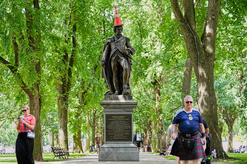 Scottish fans passing a statue of the revolutionary John Glover, humorously decorated with a traffic cone, in a park in Boston, Mass., ahead of the World Cup Group C soccer match between Scotland and Morocco, Friday, June 19, 2026. (AP Photo/Martin Meissner)