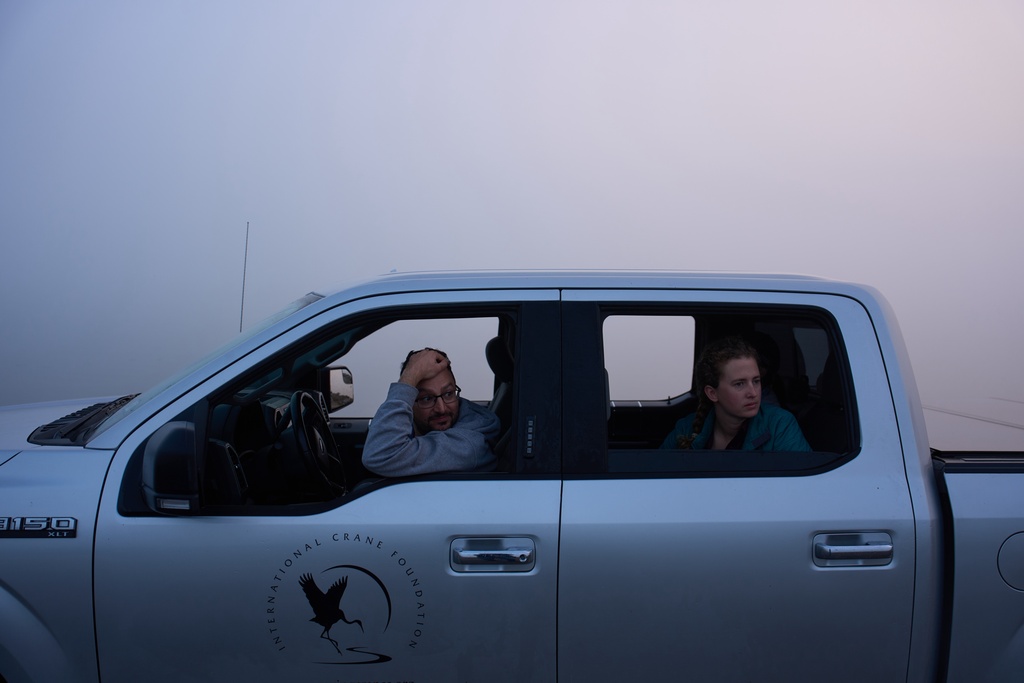 Carter Crouch, Director of Gulf Coast Programs at the International Crane Foundation, left, and Katie Fernald, Wetland/Rangeland Ecologist, International Crane Foundation, wait for fog to clear before launching a boat for whooping crane research, Friday, Dec. 12, 2025, in Rockport, Texas. (AP Photo/John Locher)