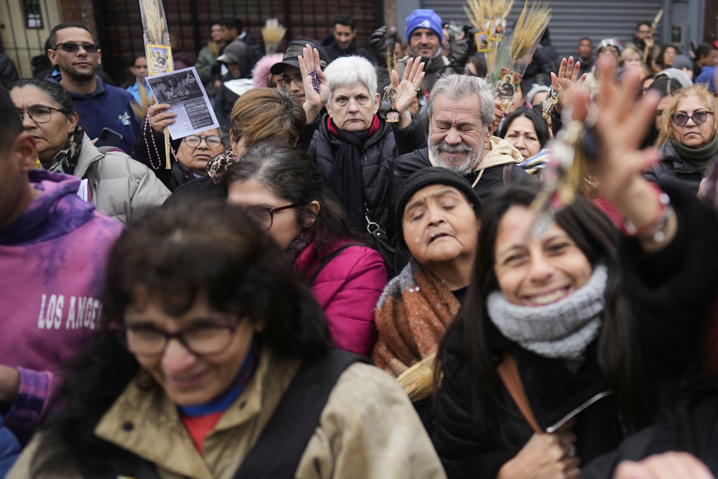 People attend a Catholic Mass outside the church of San Cayetano on the day of the annual pilgrimage honoring the patron Saint of work in Buenos Aires, Argentina, Thursday, Aug. 7, 2025. (AP Photo/Natacha Pisarenko)