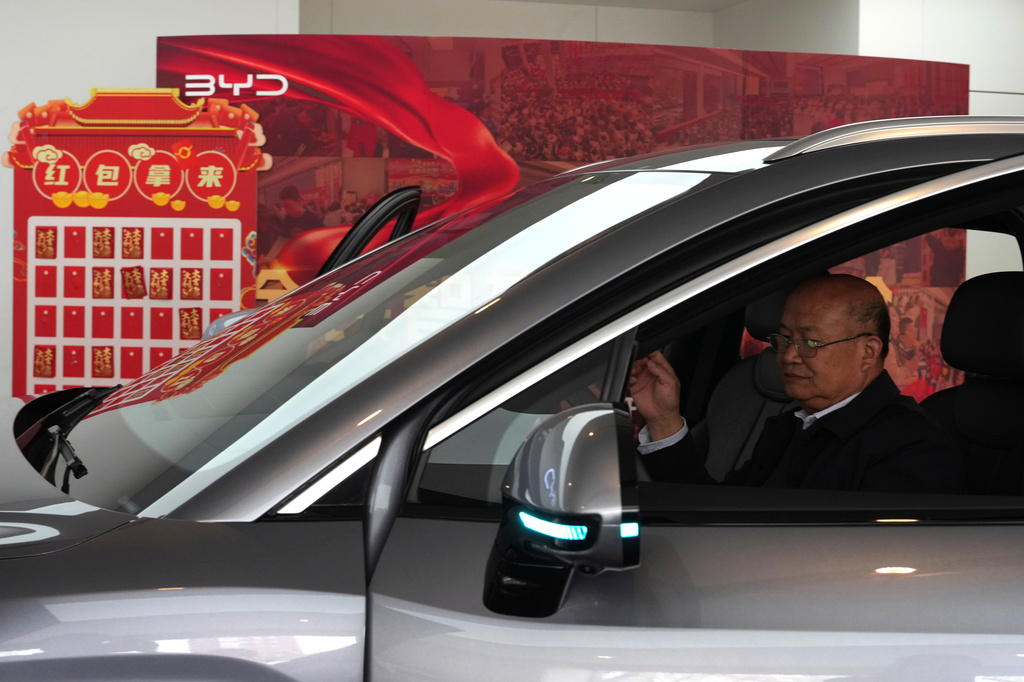 A visitor checks out a hybrid car at a BYD showroom in Beijing, China, Thursday, March 26, 2026. (AP Photo/Ng Han Guan)