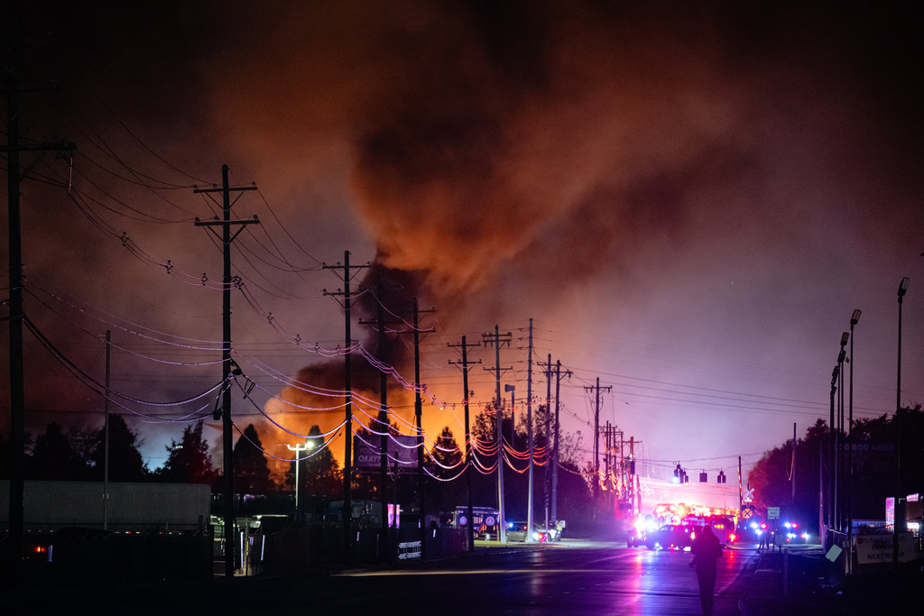 Plumes of smoke rise from the area of a UPS cargo plane crash at Louisville Muhammad Ali International Airport, on Tuesday, Nov. 4, 2025, in Louisville, Ky. (AP Photo/Jon Cherry)
