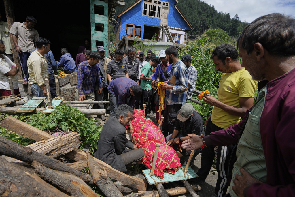 Villagers perform last rites of a woman died in a flash flood in Chositi village, Kishtwar district, Indian-controlled Kashmir, Friday, Aug. 15, 2025. (AP Photo/Channi Anand)