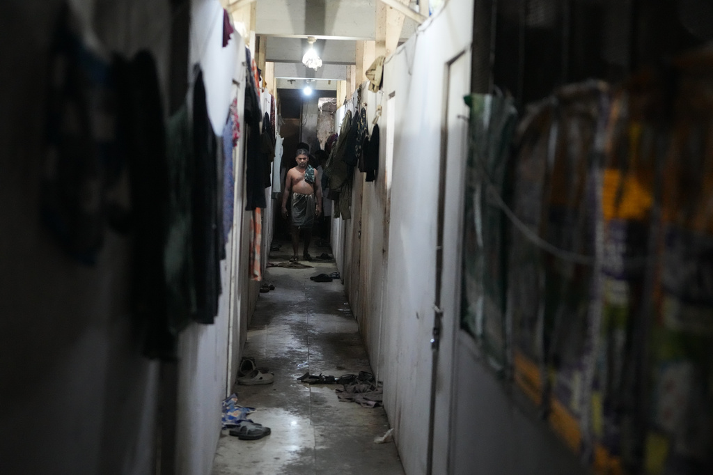 Migrant worker Sibaram Pradhan walks down a hallway after taking a bath at his residential quarters in Surat, India, Wednesday, May 27, 2026. (AP Photo/Ajit Solanki)