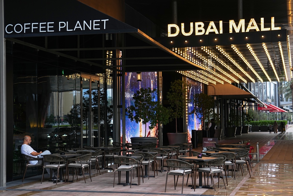 A man sits at an outdoor empty cafe in downtown Dubai, United Arab Emirates, Saturday, March 7, 2026. (AP Photo/Fatima Shbair)