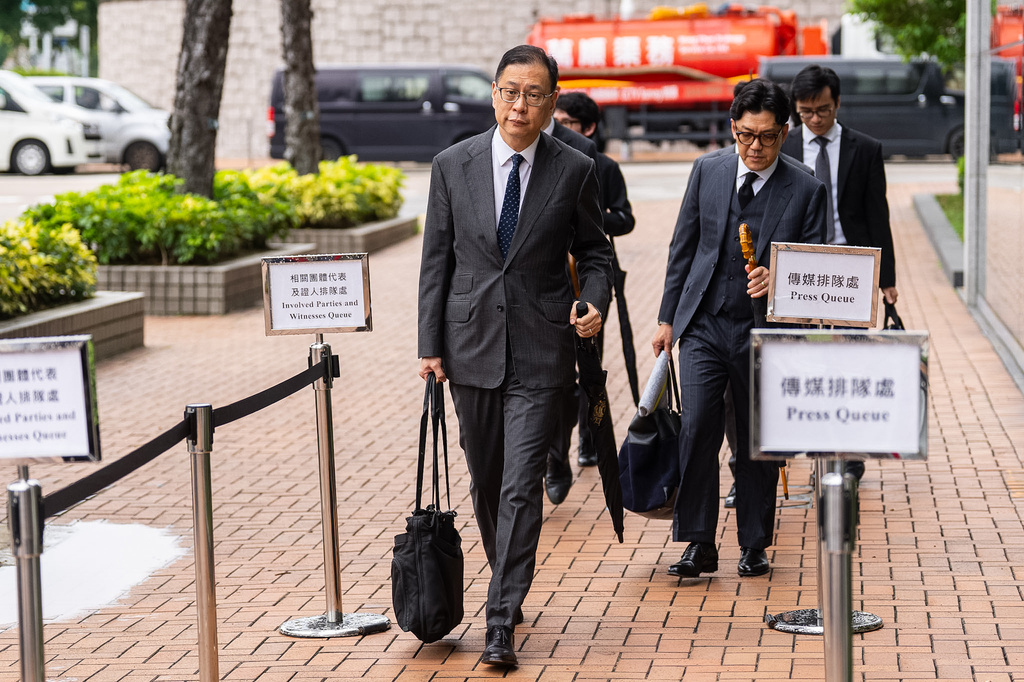 Victor Dawes, left, lead lawyer for the independent committee investigating the last year's deadly fire, arrives for the public hearing in Hong Kong, Wednesday, July 15, 2026. (AP Photo/Chan Long Hei)
