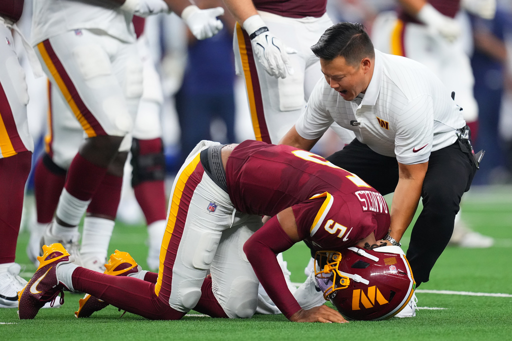 Washington Commanders quarterback Jayden Daniels (5) reacts after an apparent injury in the first half against the Dallas Cowboys during an NFL football game in Arlington, Texas, Sunday, Sept. 20, 2026. (AP Photo/Julio Cortez)