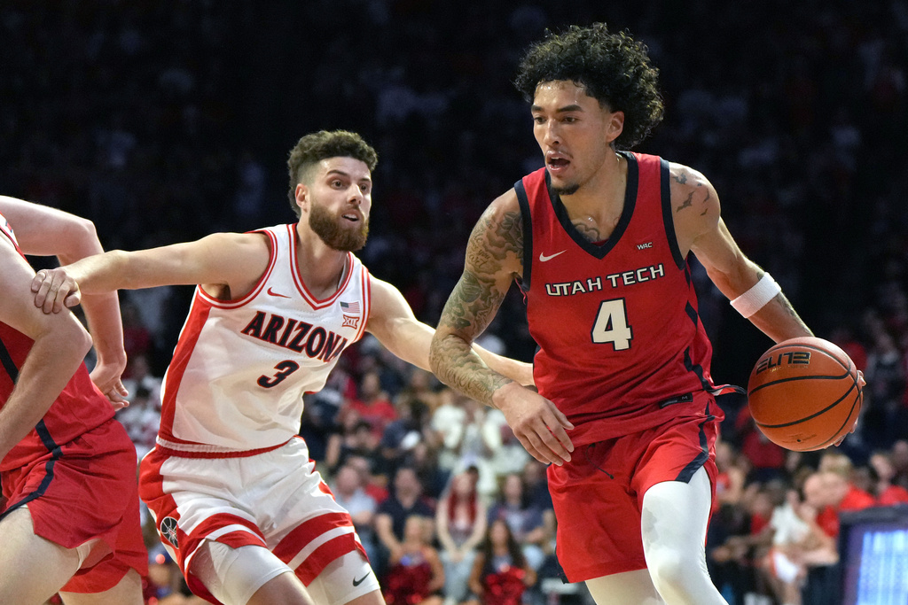 Utah Tech guard Jusaun Holt (4) drives around Arizona guard Anthony Dell'Orso during the first half of an NCAA college basketball game, Friday, Nov. 7, 2025, in Tucson, Ariz. (AP Photo/Rick Scuteri)