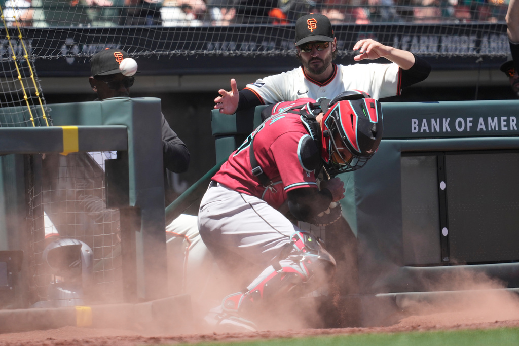 San Francisco Giants infield coach Ron Washington, top left, and manager Tony Vitello, top right, watch as Arizona Diamondbacks catcher Aramis Garcia, bottom, cannot catch a ball in foul territory hit by Will Brennan during the fifth inning of a baseball game Wednesday, May 27, 2026, in San Francisco. (AP Photo/Jeff Chiu)