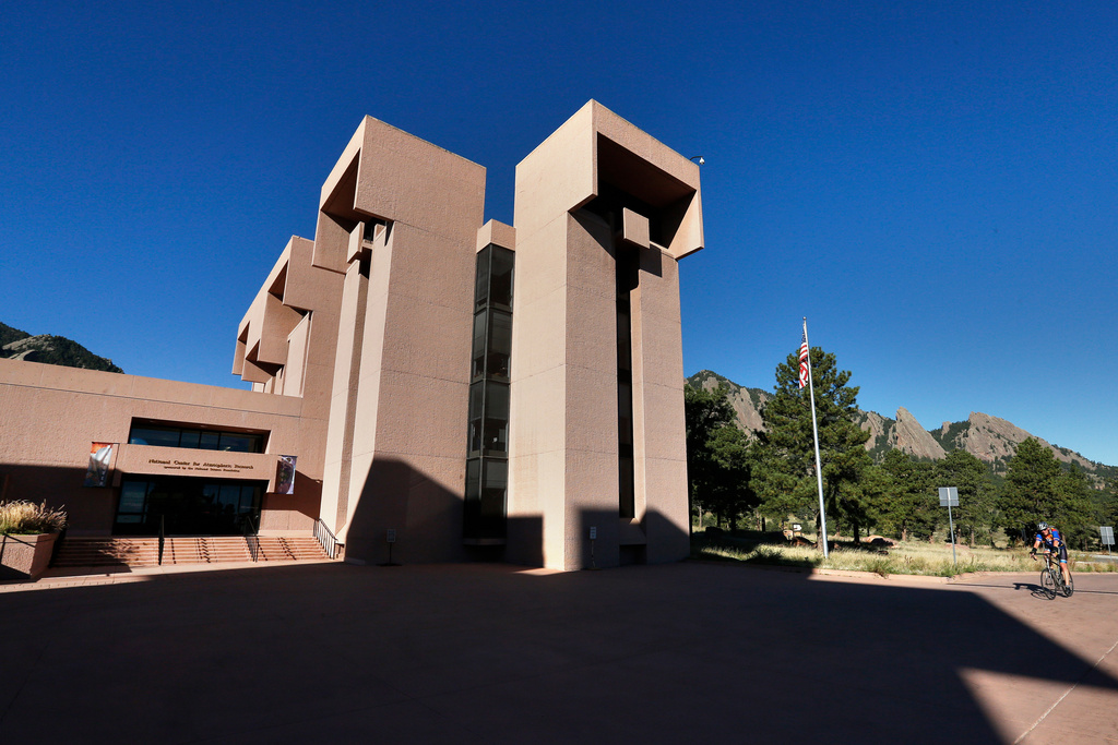 FILE - A man rides a bike to work at a U.S. National Center for Atmospheric Research facility in Boulder, Colo., Oct. 1, 2013. (AP Photo/Brennan Linsley, File)