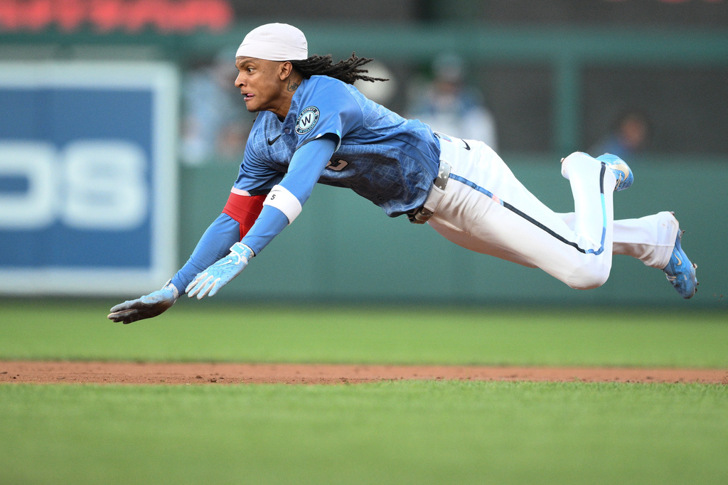 Washington Nationals' CJ Abrams dives towards second base for a double during the third inning of a baseball game against the Cincinnati Reds, Saturday, Aug. 8, 2026, in Washington. (AP Photo/Nick Wass)