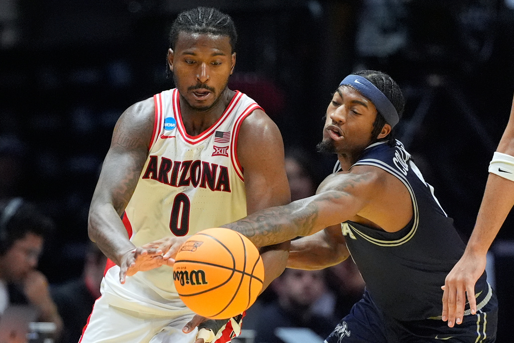 Utah State guard Mj Collins (2) attempts to steal the ball from Arizona guard Jaden Bradley (0) during the second half of a game in the second round of the NCAA college basketball tournament Sunday, March 22, 2026, in San Diego. (AP Photo/Mark J. Terrill)